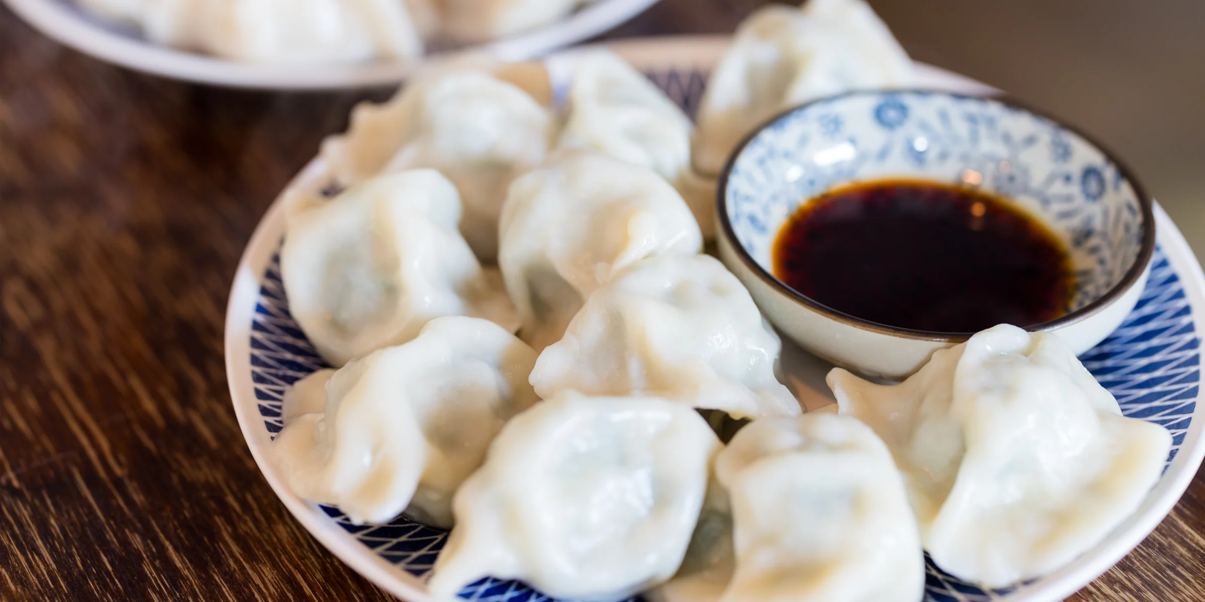 Hands folding dumplings during a Beijing dumpling-making class