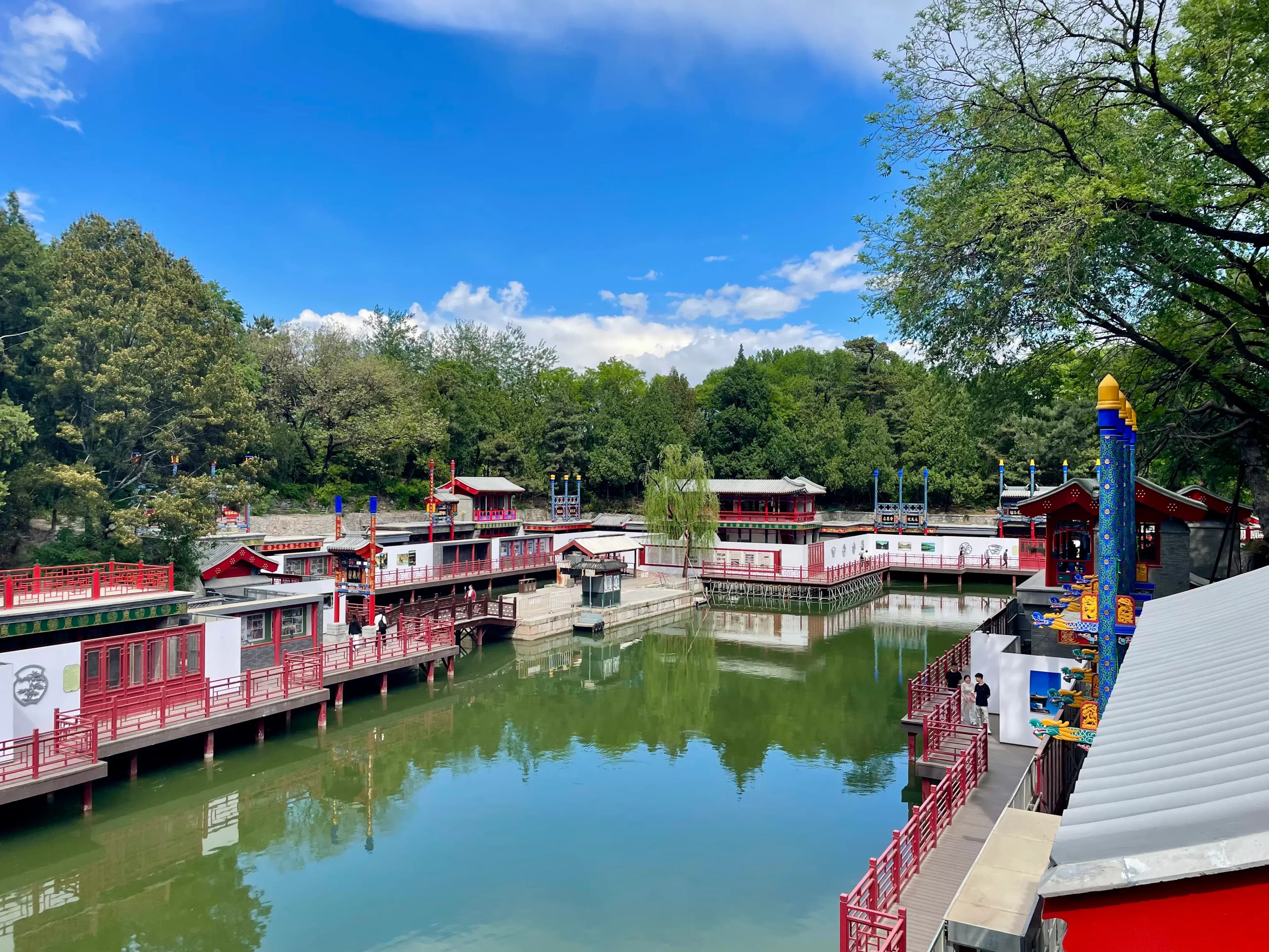 Traditional buildings and waterways along Suzhou Street in the Summer Palace surrounded by trees under blue sky in Beijing China