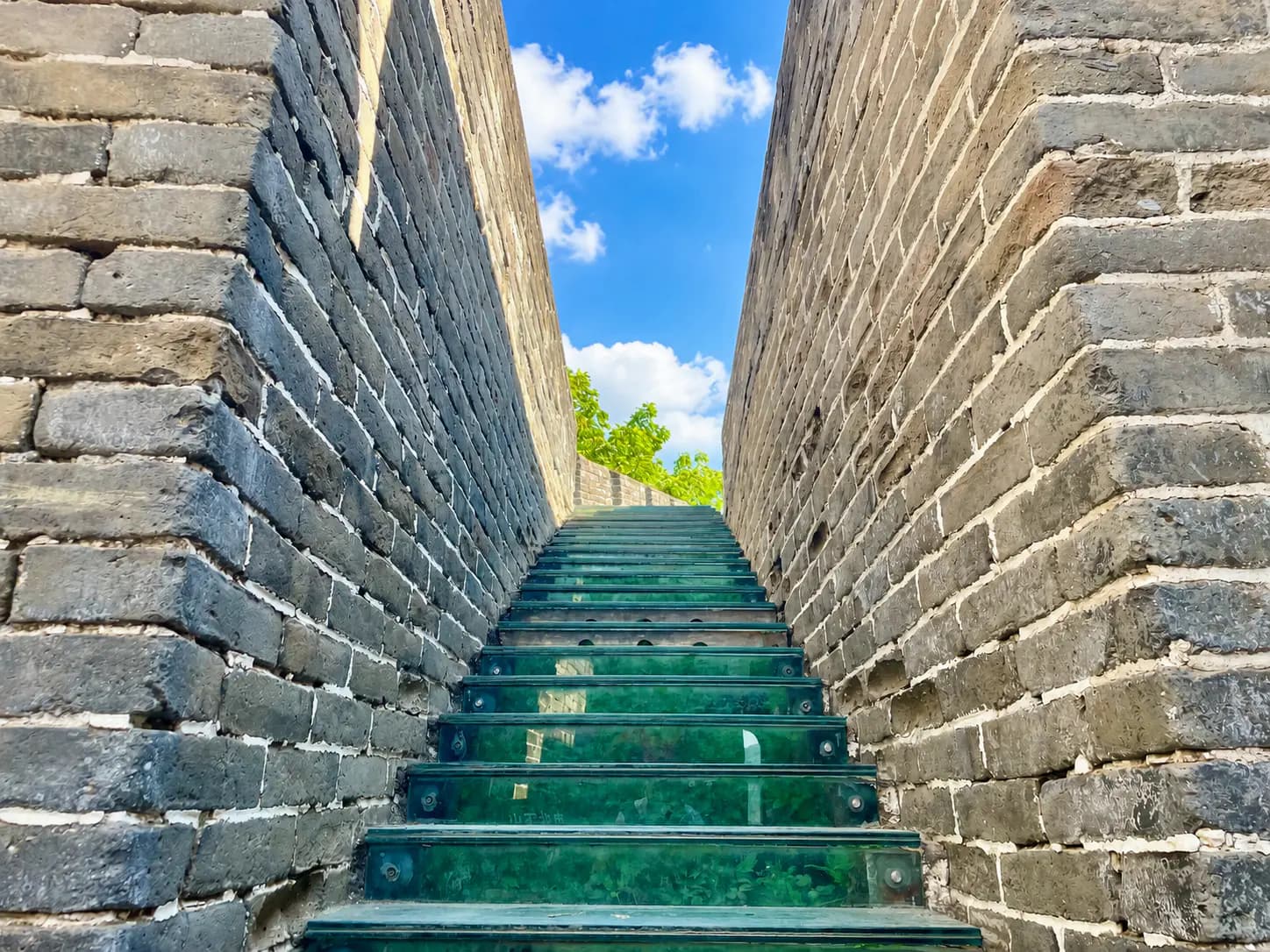 Glass Steps at Mutianyu Watchtower 10 with Ming Dynasty wall stones visible beneath the glass walkway.