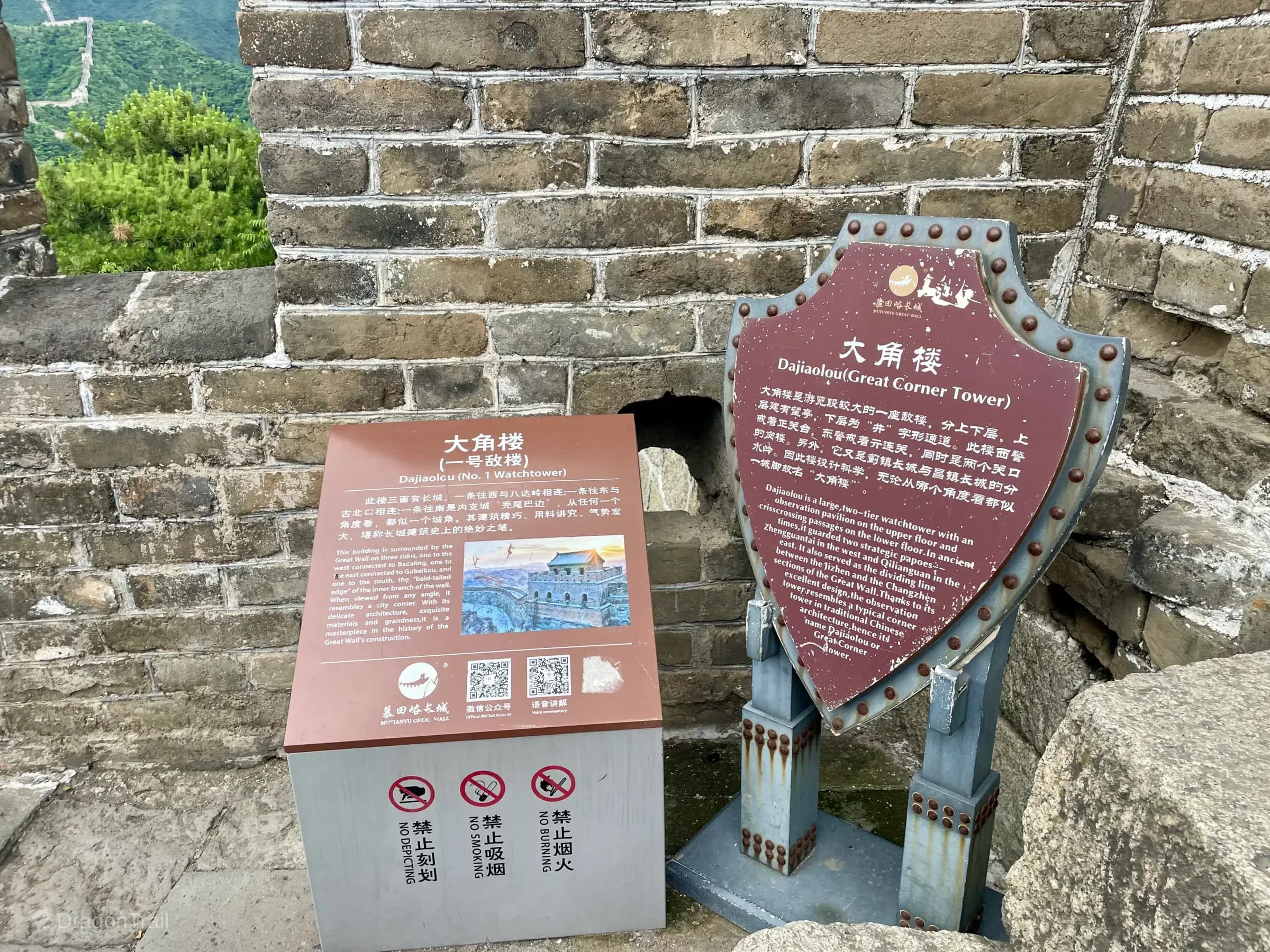 Bilingual Mutianyu signs for Dajiaolou (No. 1 Watchtower) against Great Wall brickwork with the ridge wall beyond