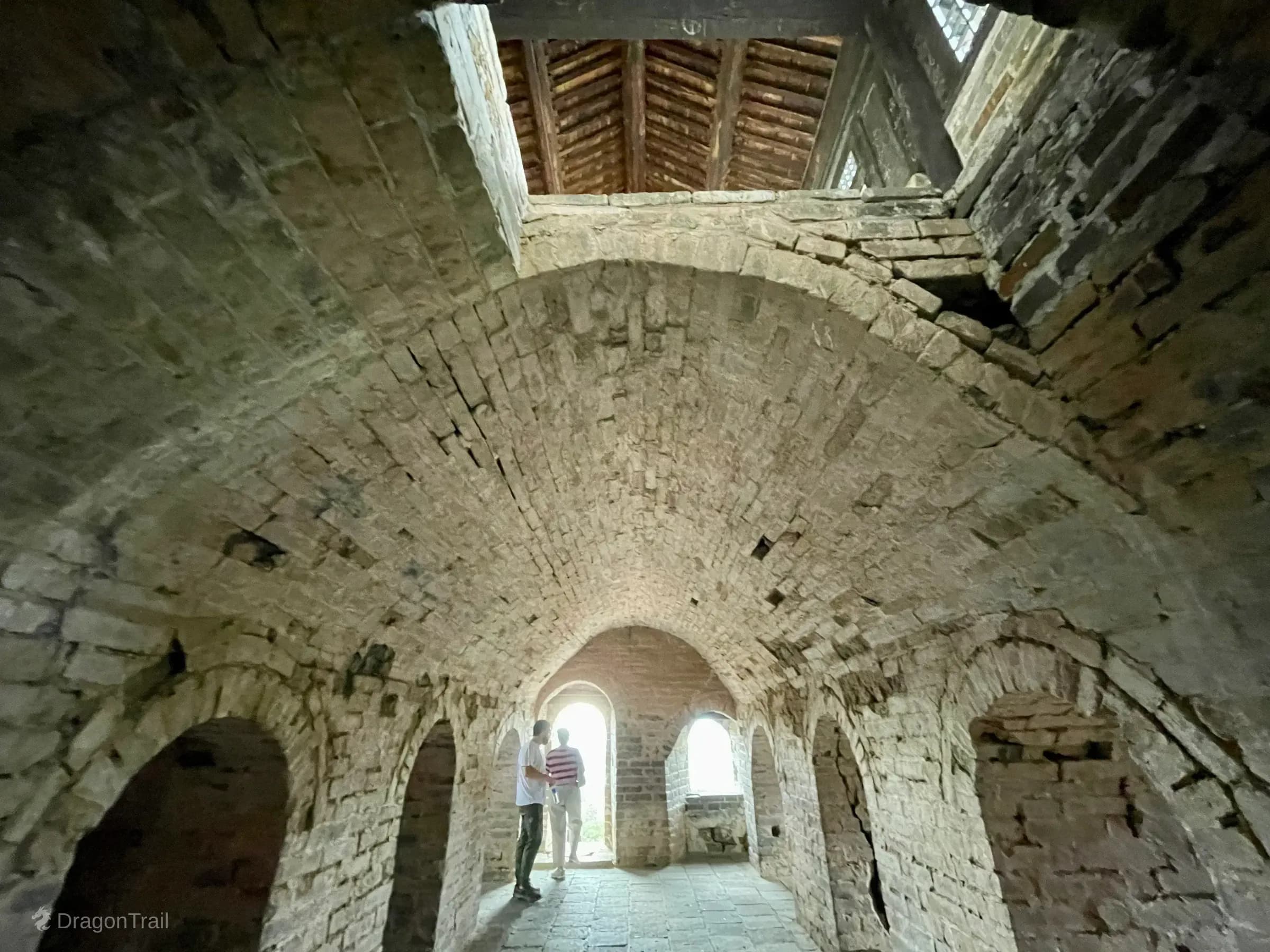 Brick barrel-vaulted passages inside Mutianyu Tower 1 with arched openings and visitors near a bright exit