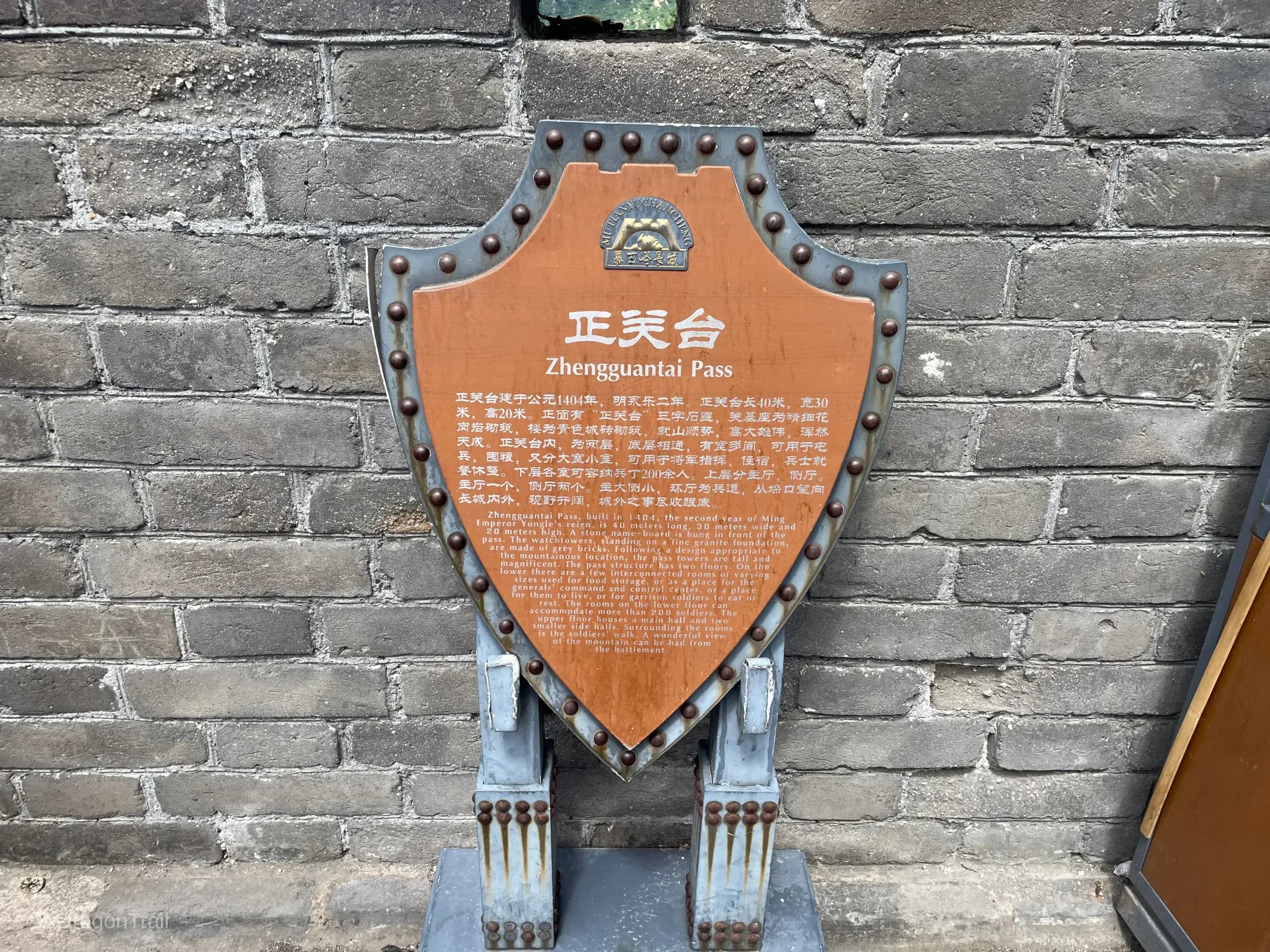 Riveted shield plaque explaining Zhengguantai Pass history and two-floor plan at Mutianyu Tower 4
