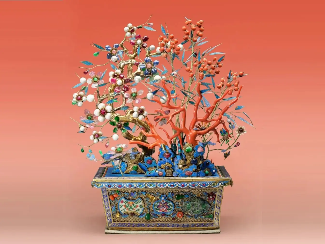 A detailed and colorful jeweled tree sculpture with flowers, leaves, and berries, set in an ornate rectangular base.