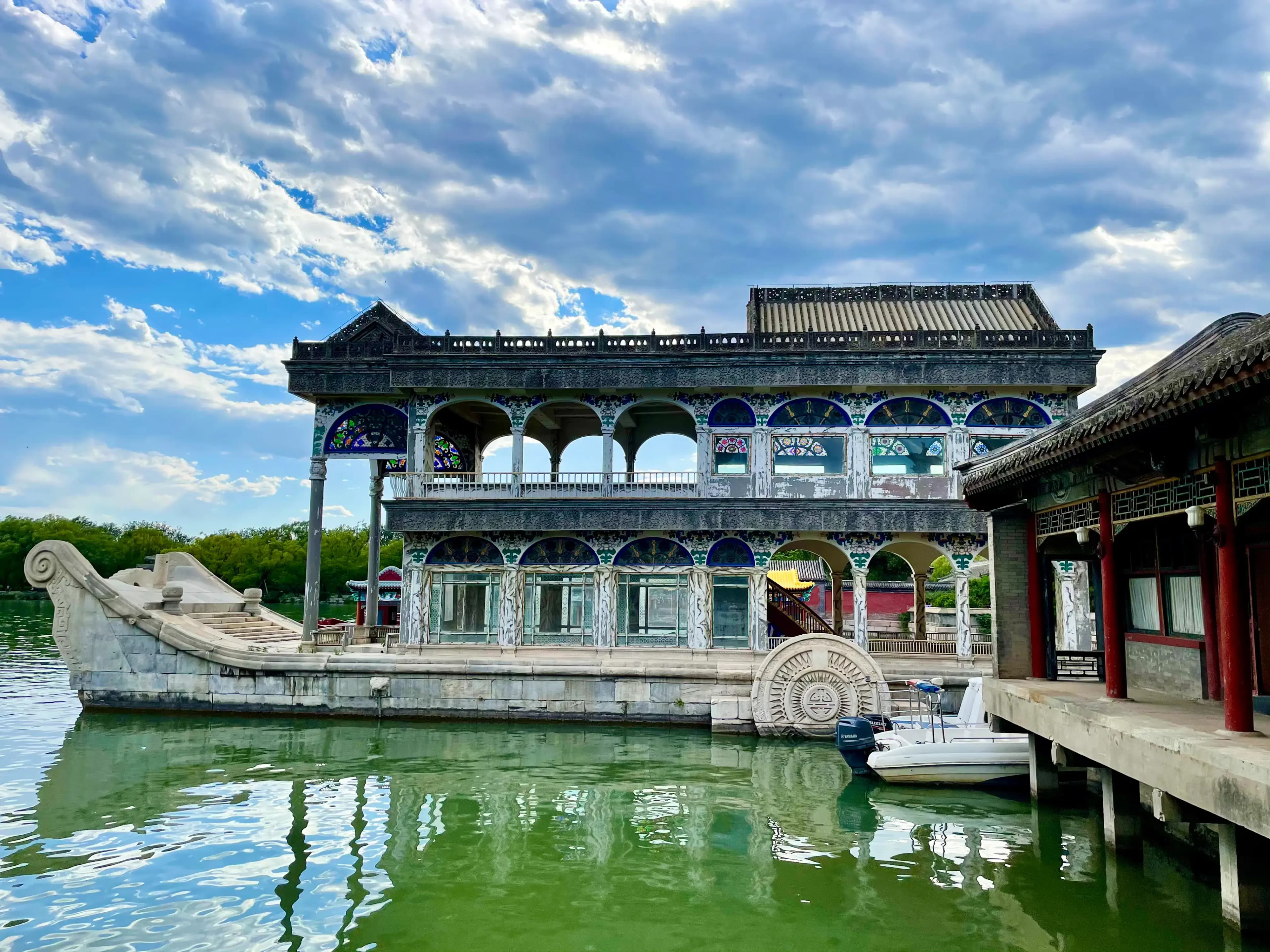 The Stone Boat at the Summer Palace beside Kunming Lake featuring marble architecture and western-style decorative details under dramatic clouds in Beijing China