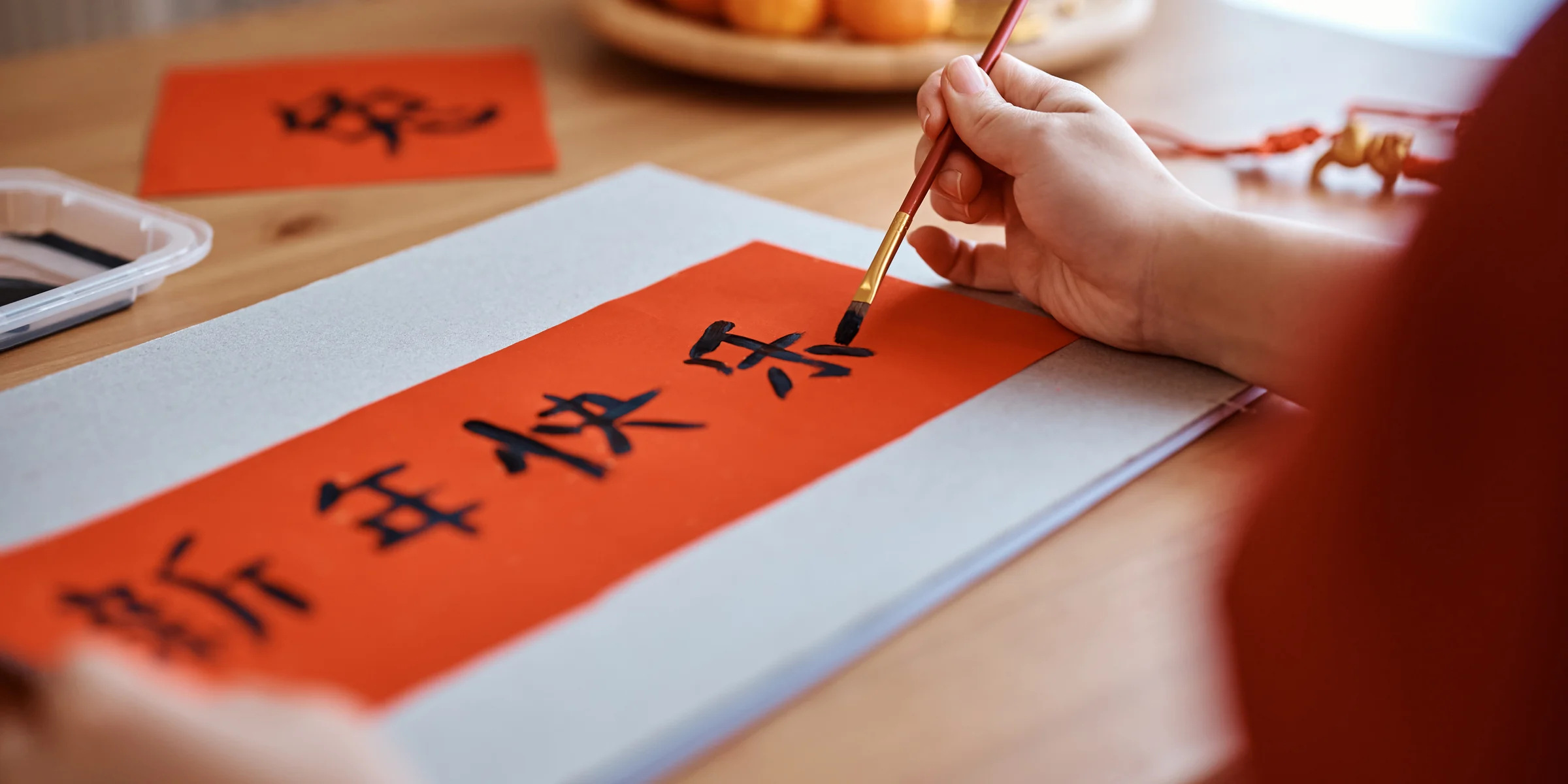 A guest practising Chinese calligraphy during a Beijing hutong cultural experience