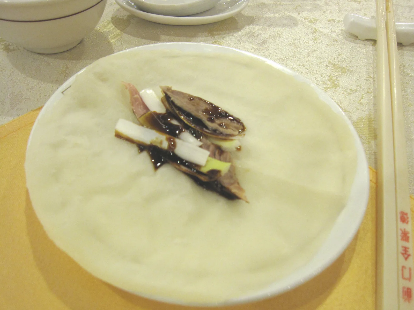 Peking duck with scallion and sauce on a thin wheat pancake