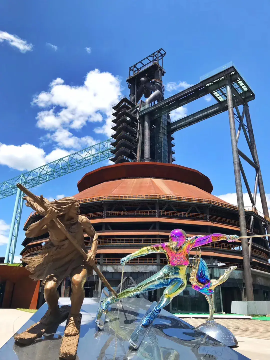 Bronze and iridescent ski sculptures in front of the blast furnace towers at Shougang Park, Beijing