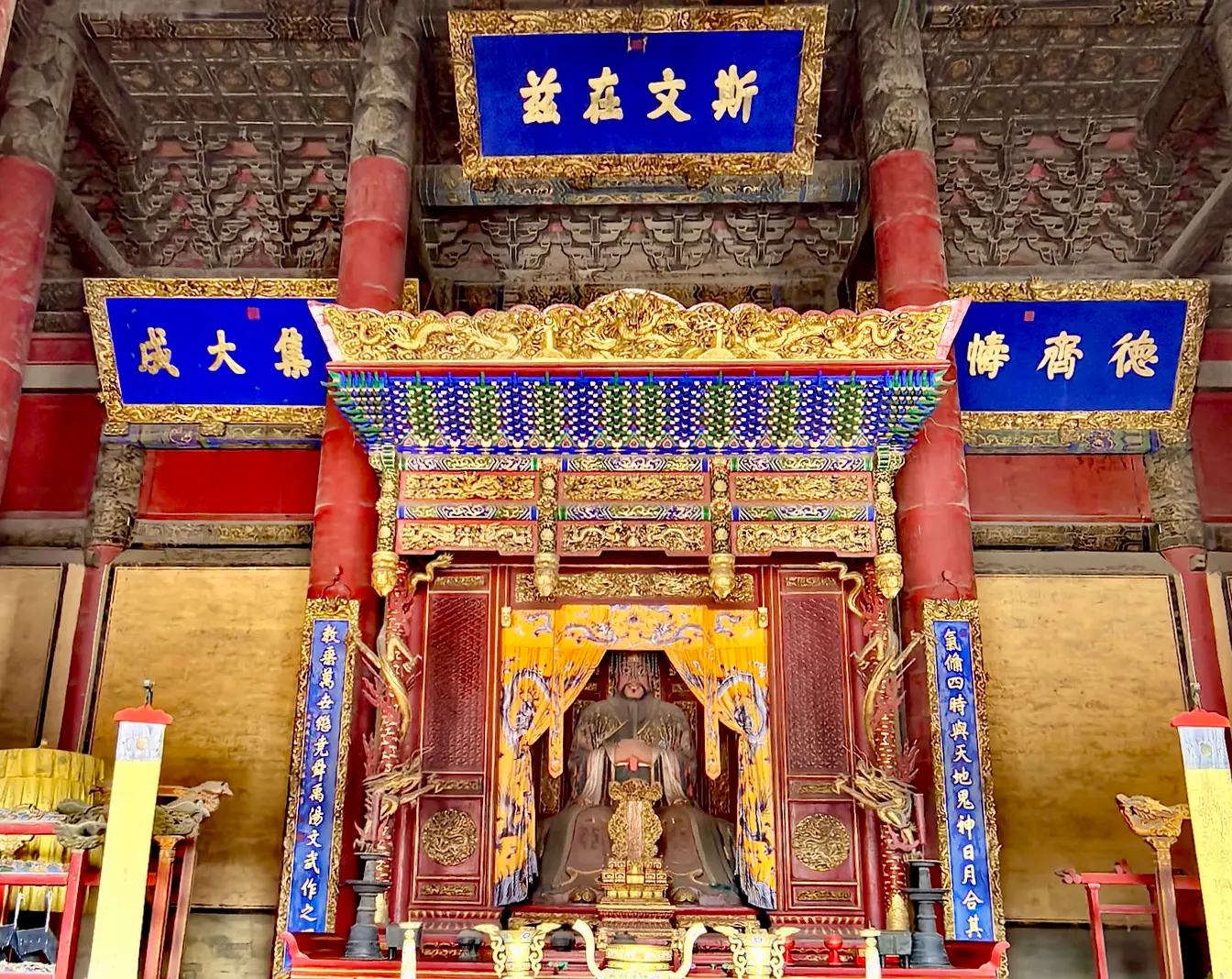 Ornamentado portal chino con columnas rojas y ménsulas dougong pintadas