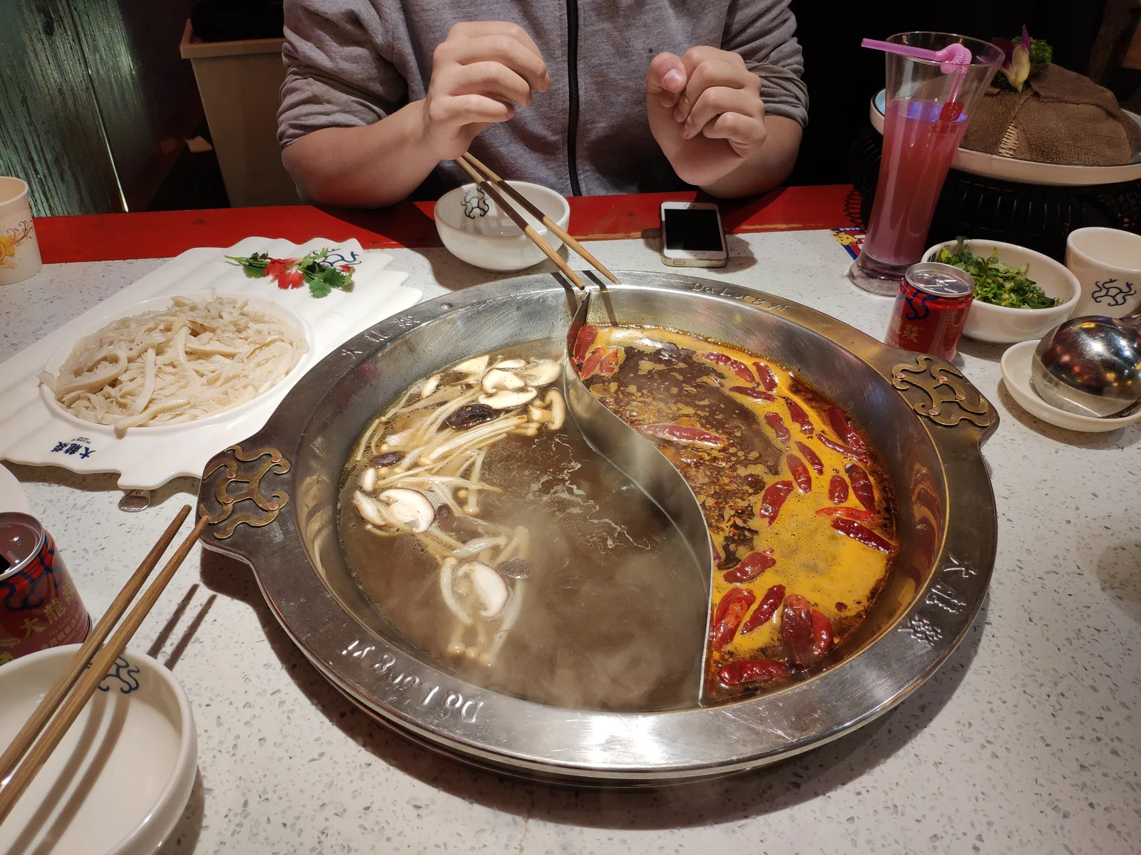 Split yuanyang hotpot pot with a spicy red broth on one side and a mild broth on the other