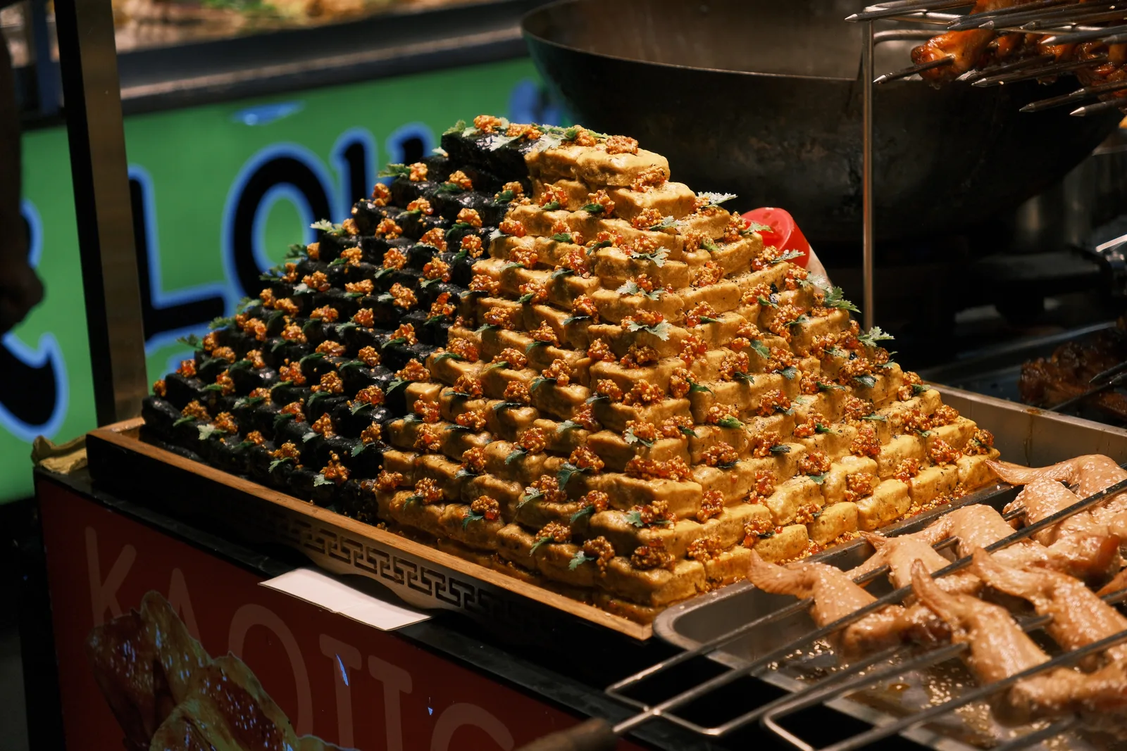Chinese street food stall with griddle, steamers and queued customers