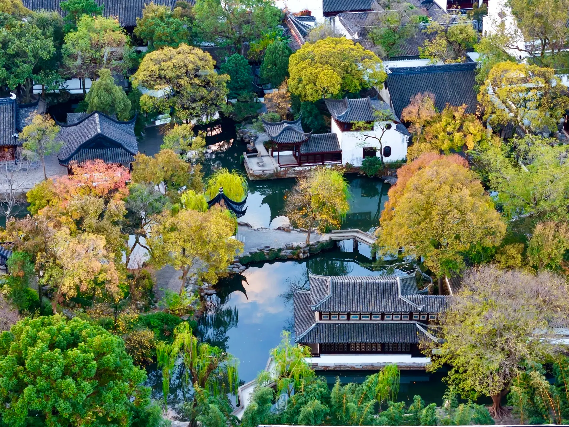 Main elements of a traditional Chinese garden including rocks, water, pavilion, corridor, moon gate and plants