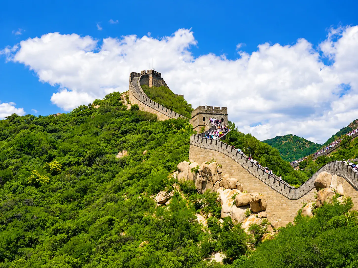Visitors walking the restored Badaling Great Wall ridge between watchtowers.