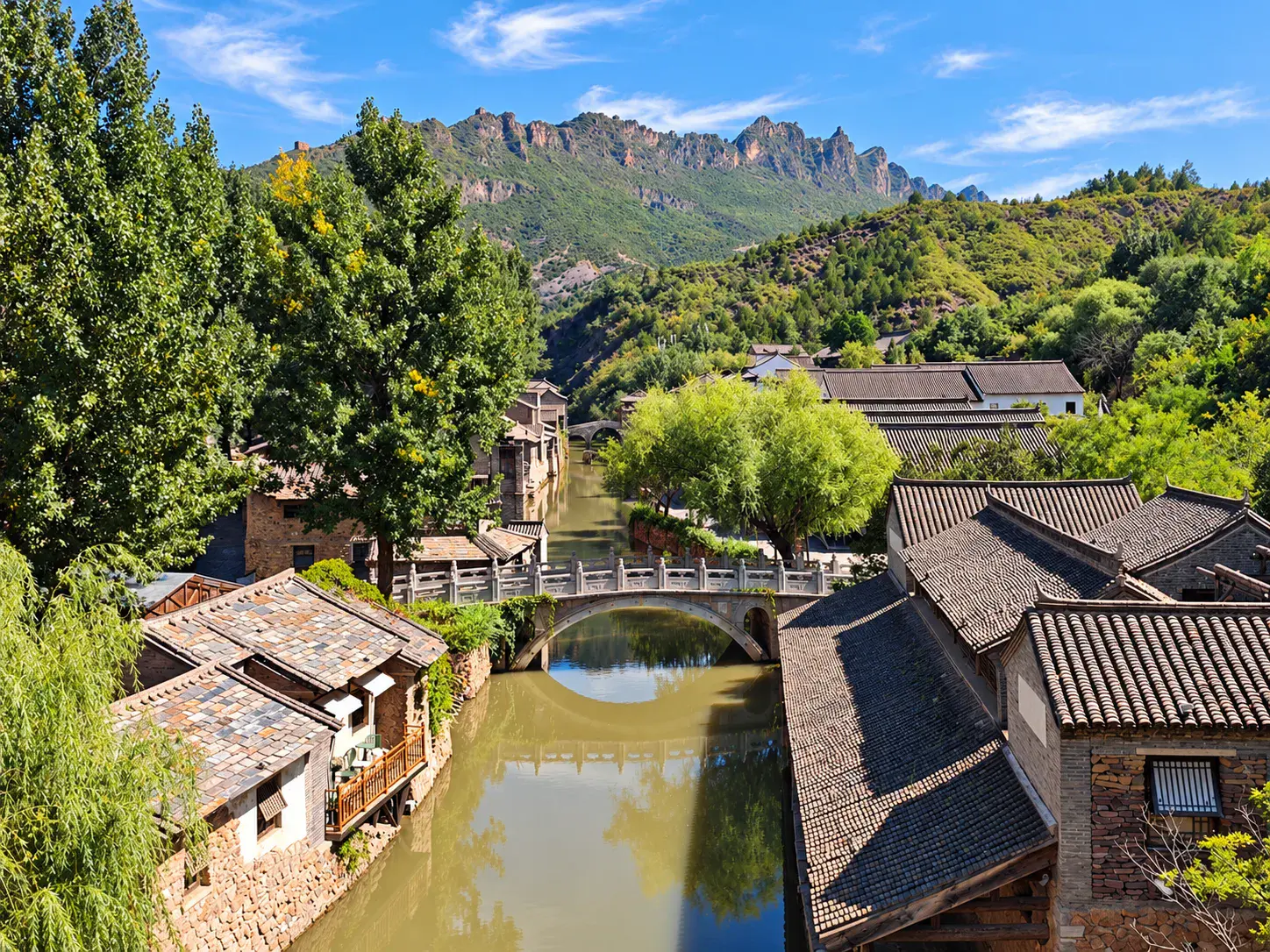 Stone bridge over a canal in Gubei Water Town, with traditional-style buildings along the water