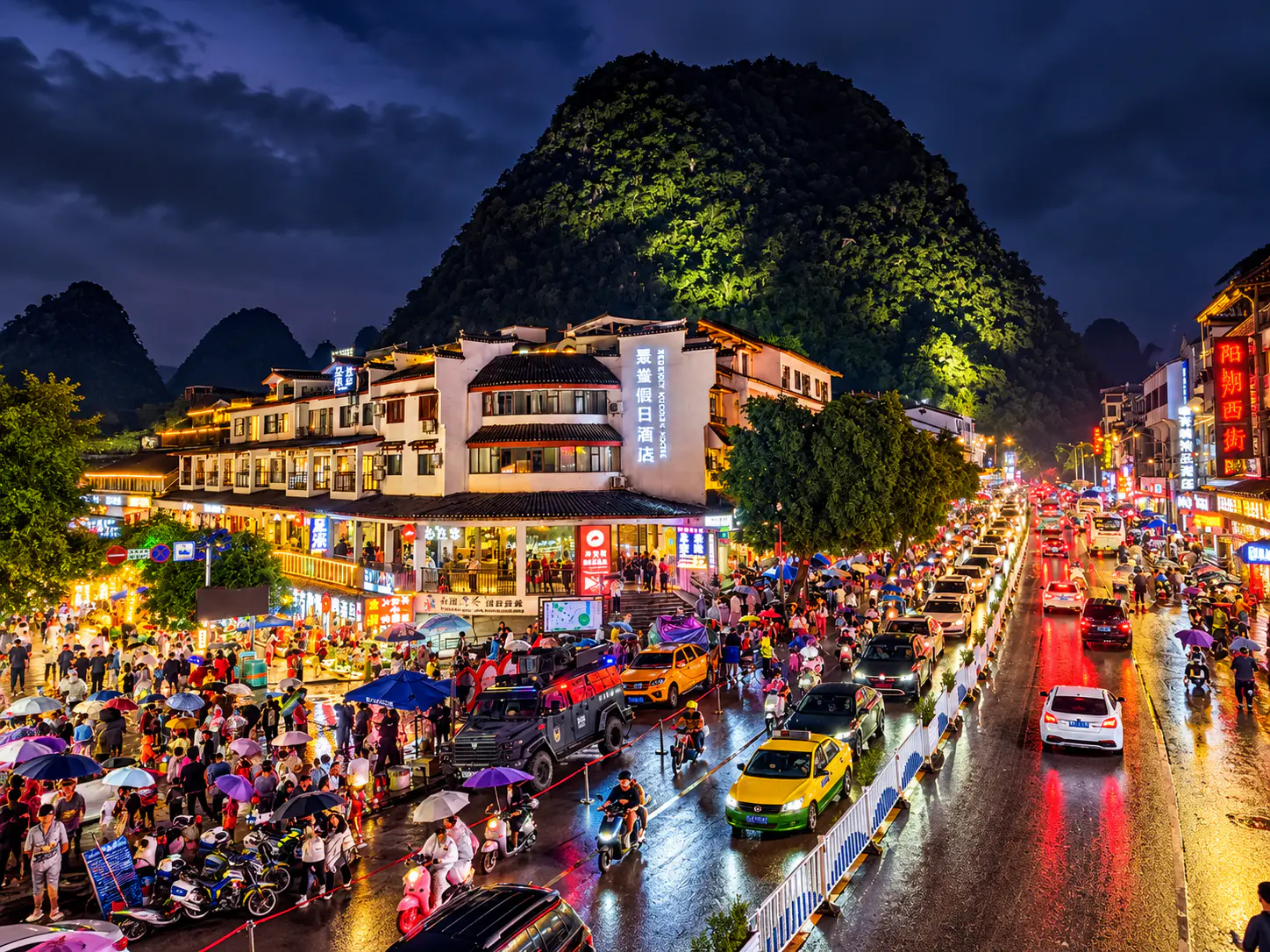 Die zentrale West Street in Yangshuo bei Nacht mit beleuchteten Geschäften und Restaurants