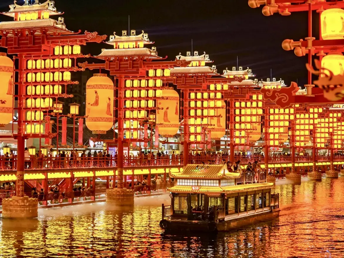 Lantern-lit pleasure boat and red pavilion lights at night in Tangshan