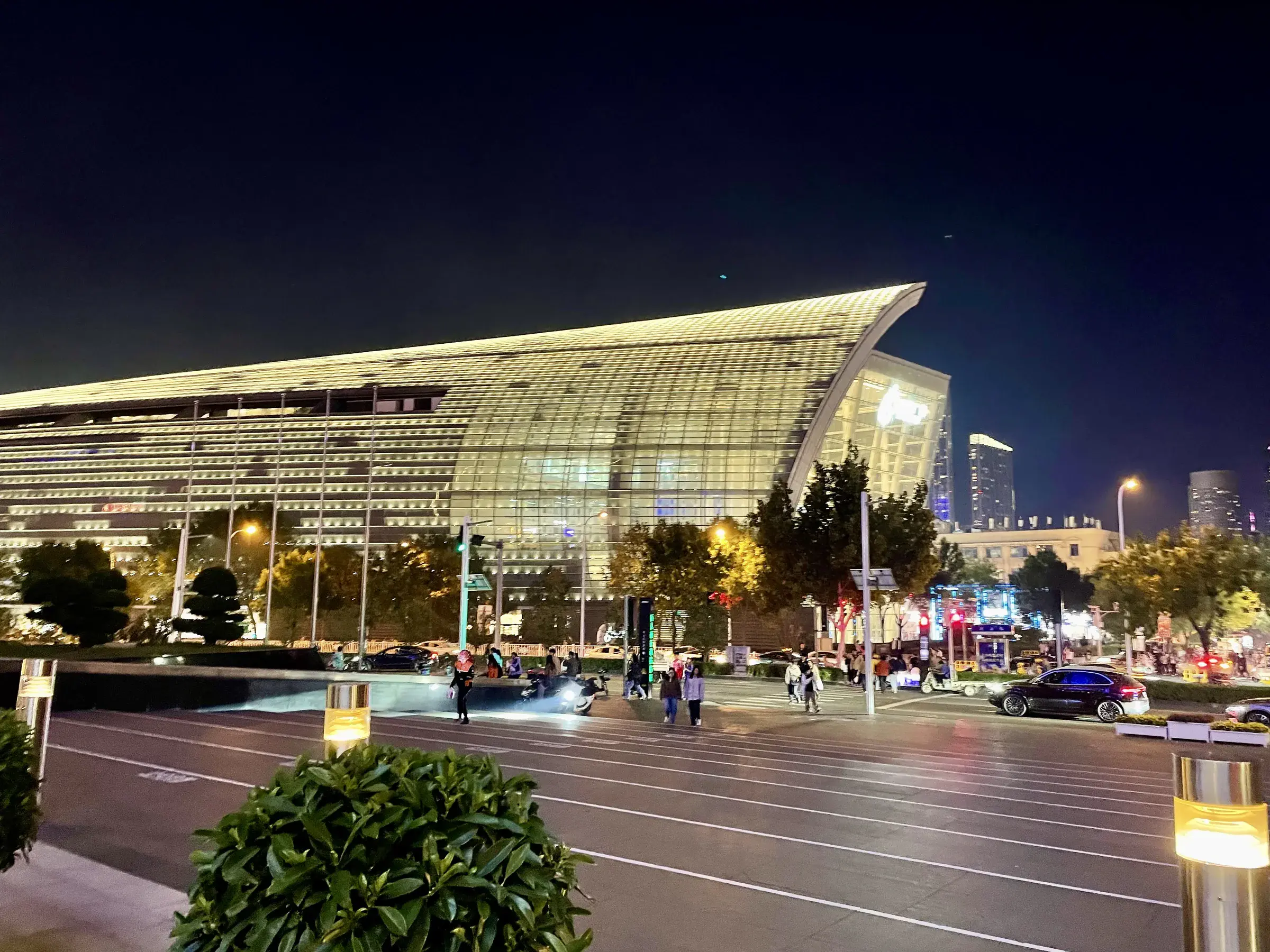 Large curved glass-roofed cultural building lit at night in Tianjin