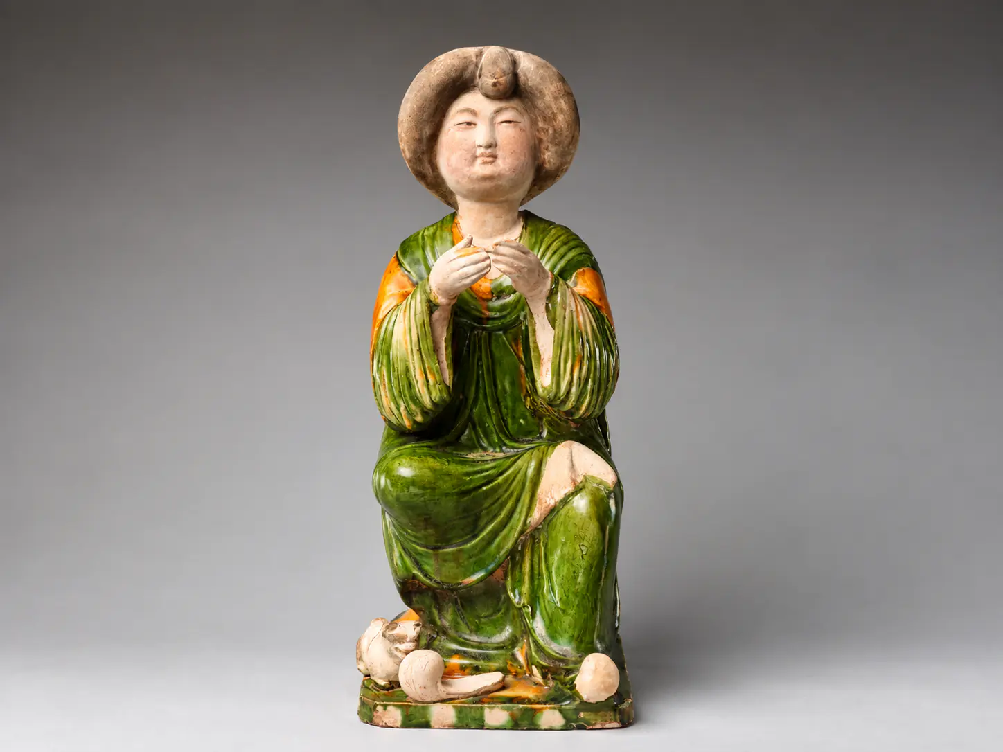 Figura de cerámica pintada de una dama de la corte Tang con una túnica verde y naranja