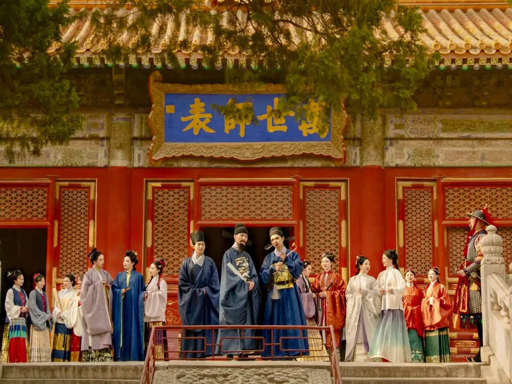 Grupo con ropa tradicional china moderna fuera de un edificio ornamentado