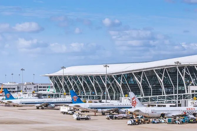 Xi'an Airport terminal building with multiple airplanes parked at the gates, including China Eastern and Hainan Airlines.